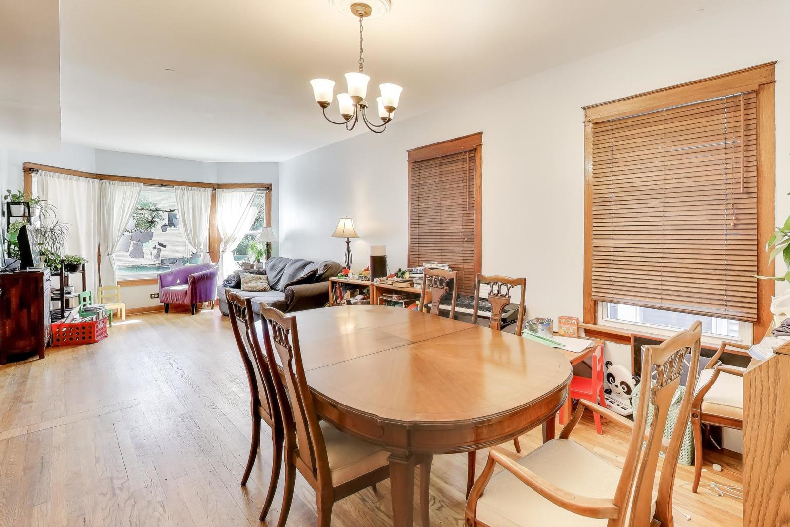 4154 North Campbell Avenue Chicago, IL 60618 - Photo 5 of 28 a dining room with furniture a window and wooden floor