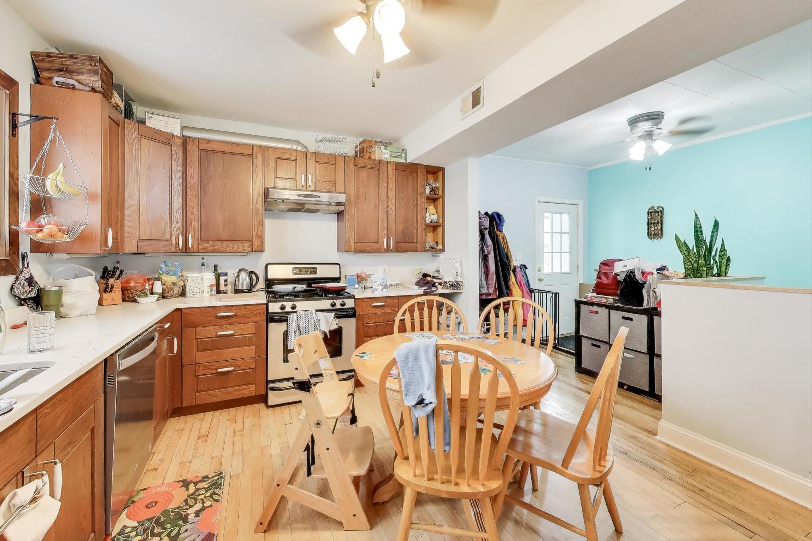 4154 North Campbell Avenue Chicago, IL 60618 - Photo 7 of 28 a very nice looking open dining room with kitchen island stainless steel appliances a stove a sink and a refrigerator