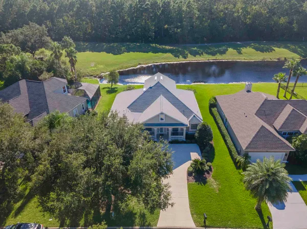 a view of a lake with a yard and a large tree