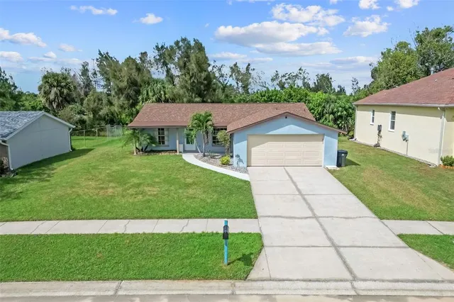 a front view of a house with a garden and trees