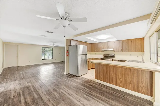 a view of a kitchen with a sink cabinets and stainless steel appliances