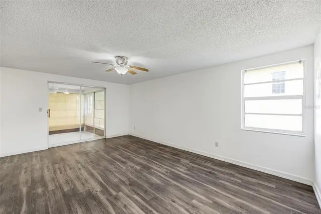 an empty room with a window and a ceiling fan