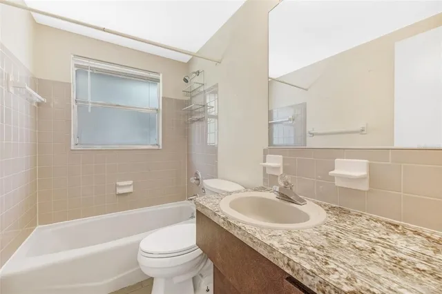a bathroom with a granite countertop sink a toilet and a mirror