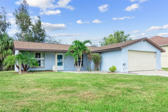 a front view of a house with a yard and potted plants