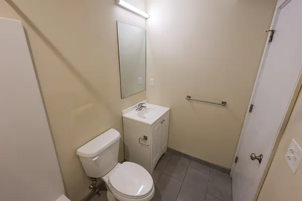 a white toilet sitting next to a white sink and vanity