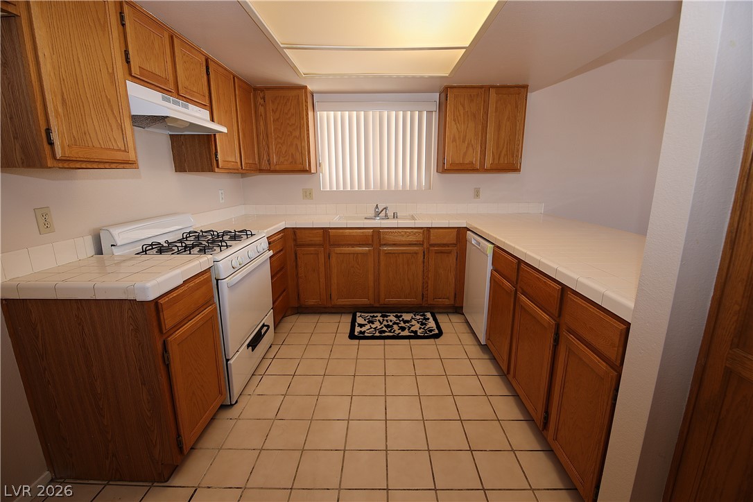 8220 Maplestar Road Las Vegas, NV 89128 - Photo 8 of 29 A well-appointed kitchen offering extensive cabinetry and a classic tile countertop.