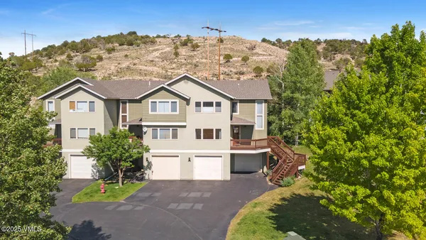 a front view of a house with a garden and trees