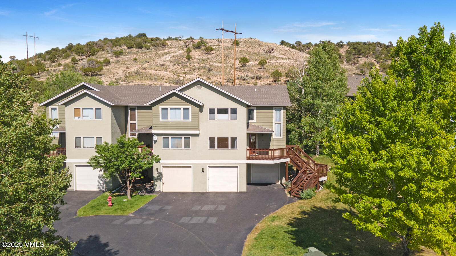 a front view of a house with a garden and trees