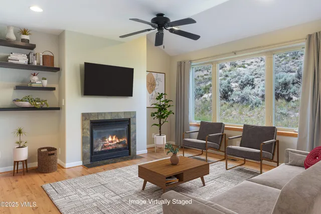 a living room with furniture a flat screen tv and a fireplace