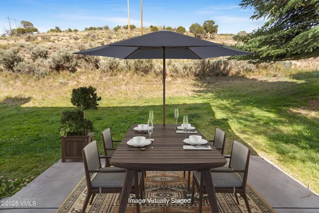 a view of a chairs and table in patio with a lake view
