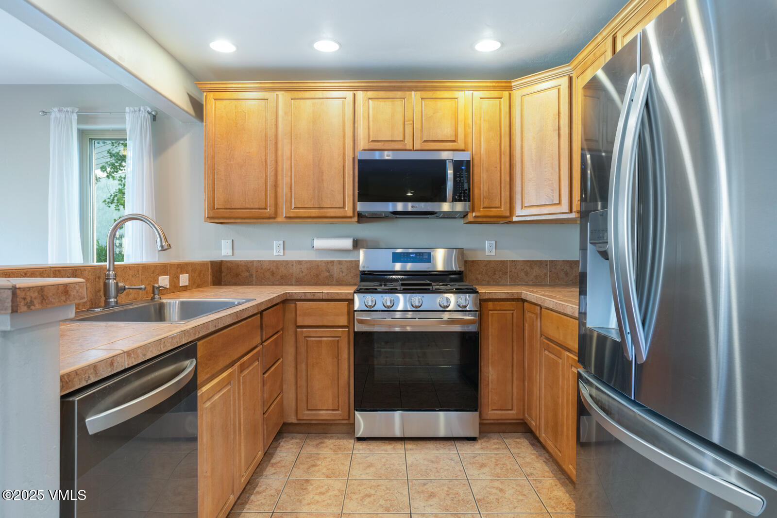 60 Mill Road, Unit J1 Eagle, CO 81631 - Photo 9 of 31 a kitchen with stainless steel appliances granite countertop a refrigerator sink and stove