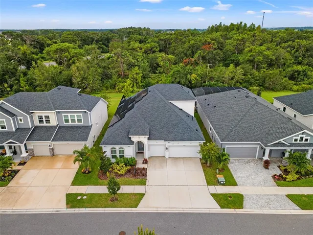an aerial view of residential houses with outdoor space and swimming pool