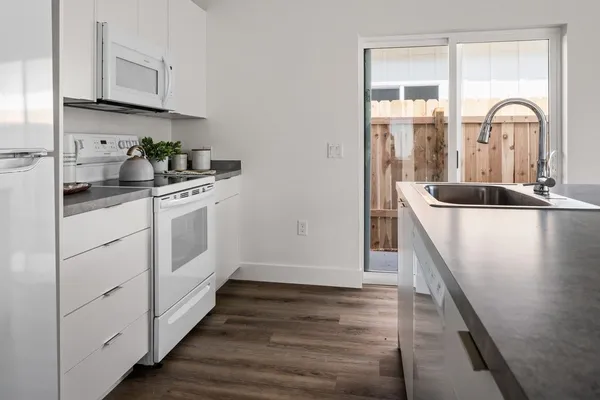 a kitchen with kitchen island granite countertop a sink and wooden cabinets