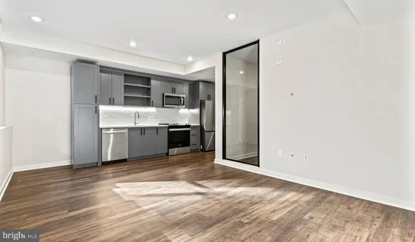 a living room with stainless steel appliances granite countertop a washer and dryer