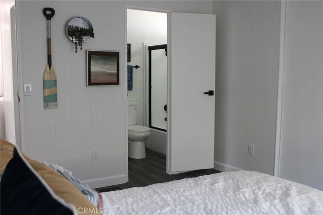 a bedroom with a bed and a painting on the wall