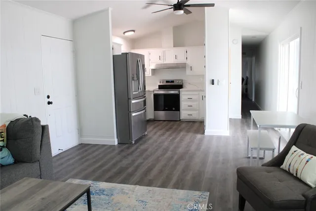 a kitchen with stainless steel appliances a refrigerator and wooden floor