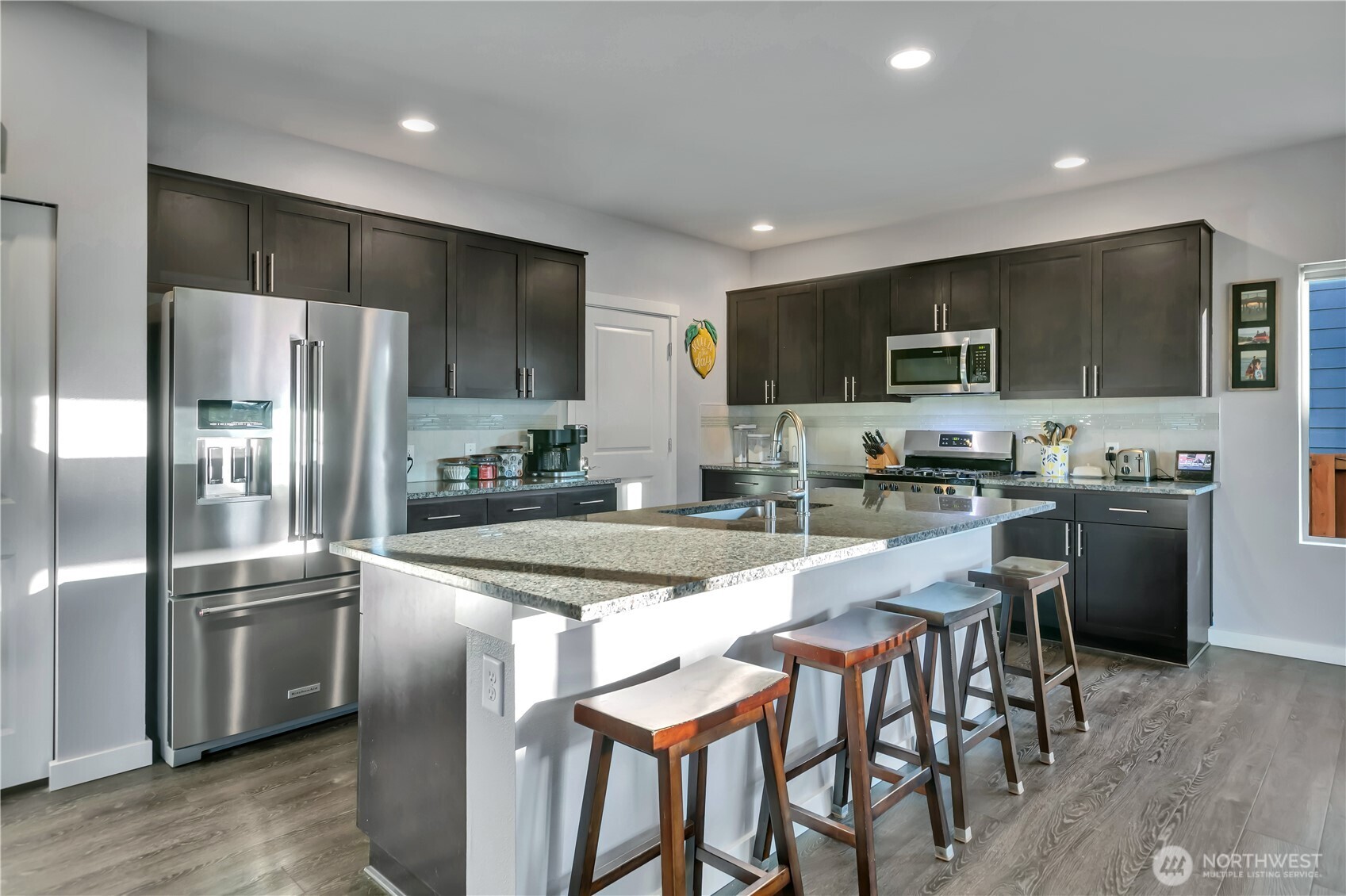 291 South Sergeant Street Buckley, WA 98321 - Photo 11 of 38 a kitchen with stainless steel appliances granite countertop a dining table chairs refrigerator and microwave