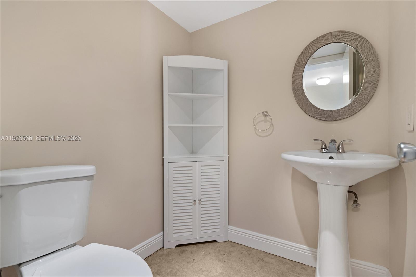 4714 Southwest 67th Avenue, Unit C1 Miami, FL 33155 - Photo 17 of 37 a bathroom with a sink a toilet and a mirror