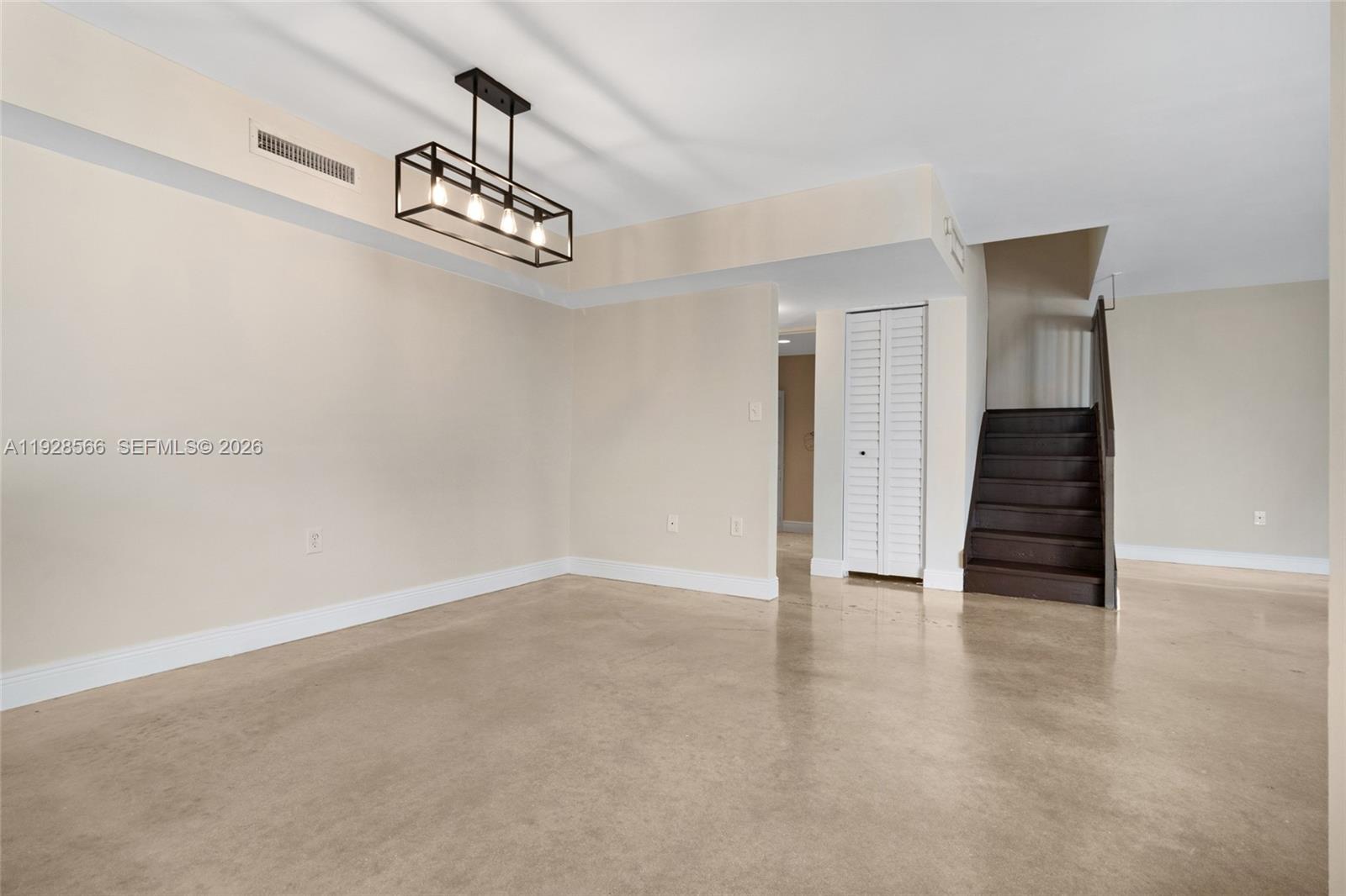 4714 Southwest 67th Avenue, Unit C1 Miami, FL 33155 - Photo 7 of 37 a view of an empty room with wooden floor and stairs