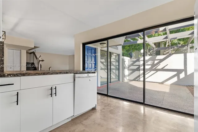a kitchen with white cabinets and a wooden floor