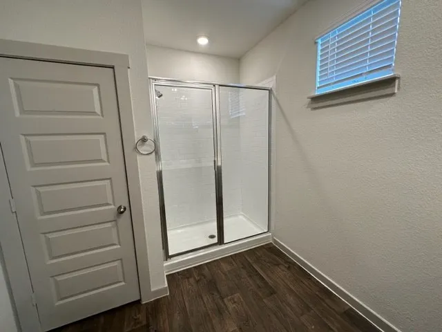 a view of empty room with wooden floor