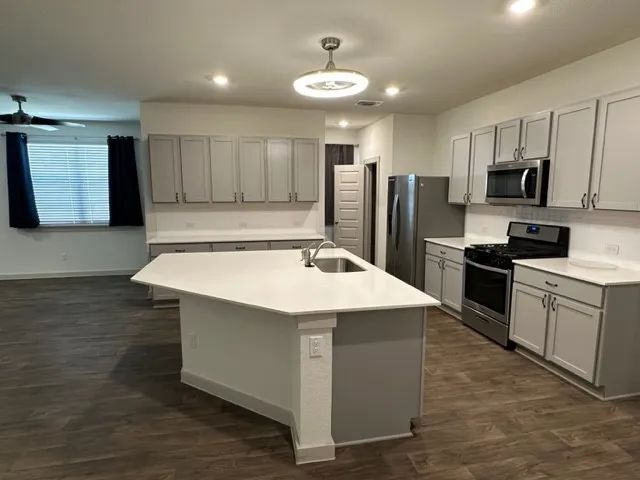 a kitchen with kitchen island a sink stainless steel appliances and cabinets