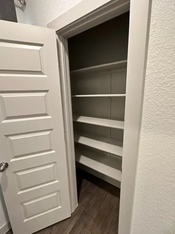 a view of walk in closet with empty racks