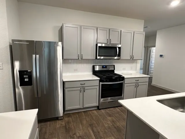 a kitchen with a refrigerator stove and microwave