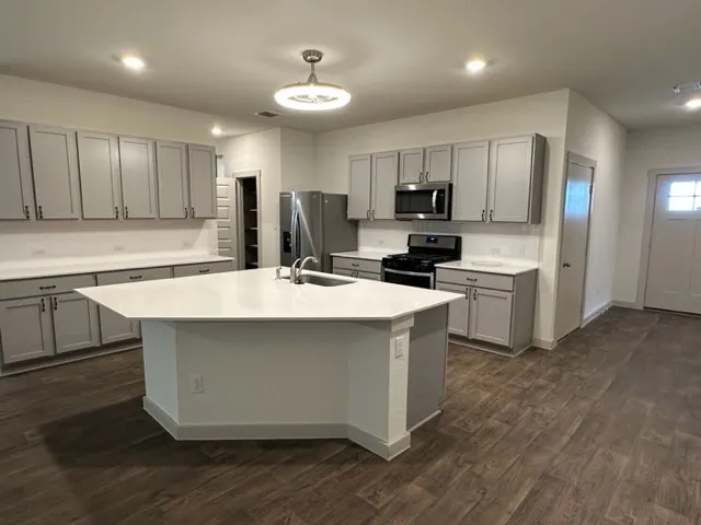a kitchen with kitchen island a sink stainless steel appliances and cabinets