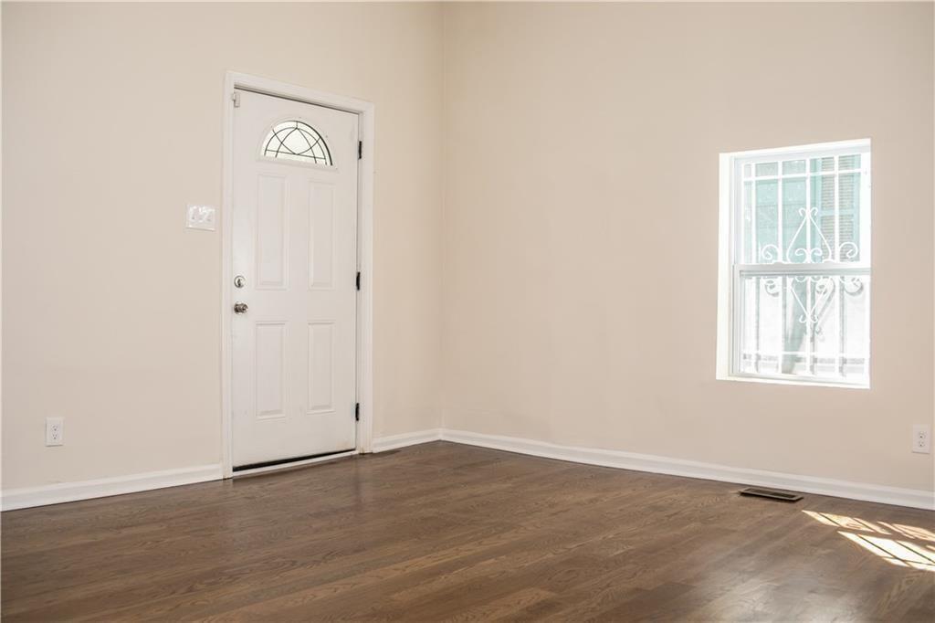 911 Smith Street Southwest Atlanta, GA 30310 - Photo 12 of 13 an empty room with wooden floor and windows