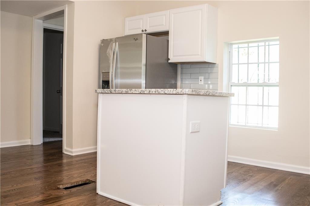 911 Smith Street Southwest Atlanta, GA 30310 - Photo 5 of 13 an empty room with wooden floor and windows