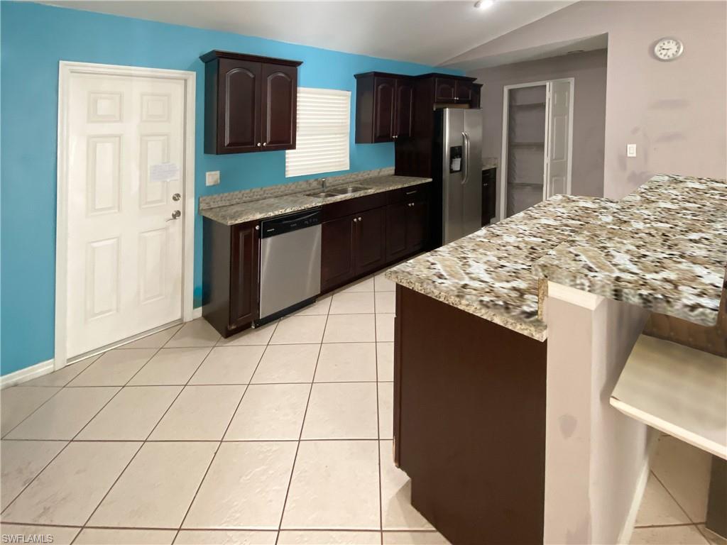 8133 Egret Road Fort Myers, FL 33967 - Photo 3 of 4 a kitchen with stainless steel appliances granite countertop a stove a sink and a refrigerator