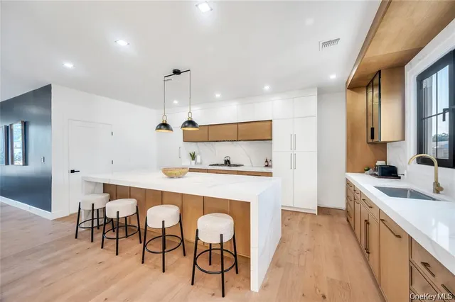 a kitchen with stainless steel appliances granite countertop sink a stove a refrigerator dining table and chairs