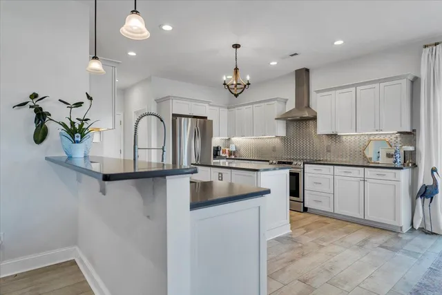 a kitchen with stainless steel appliances granite countertop a sink a stove and chairs