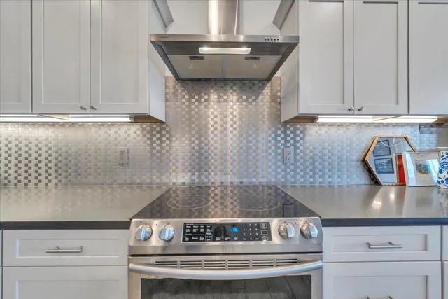 a kitchen with kitchen island a sink stainless steel appliances and living room view