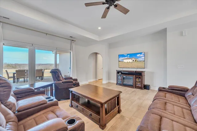 a view of a dining room and livingroom with furniture wooden floor a chandelier