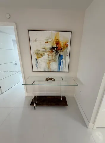 a bedroom with a bed and a flat tv screen on dresser