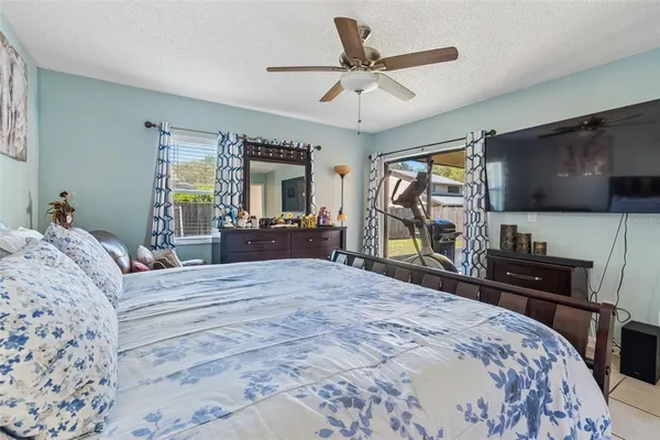 a bedroom with a bed flat screen tv and a dresser