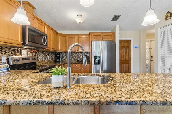 a kitchen with stainless steel appliances granite countertop a stove refrigerator and cabinets