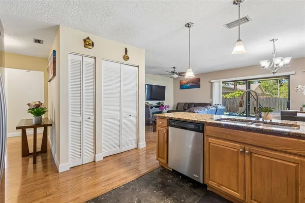 a kitchen with kitchen island granite countertop a sink a counter space appliances and cabinets