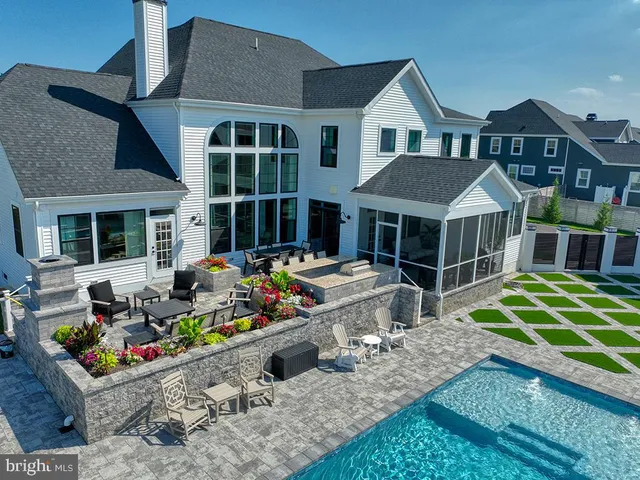 a view of a house with backyard swimming pool and sitting area