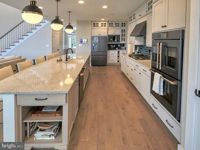 a kitchen with kitchen island granite countertop a sink and cabinets