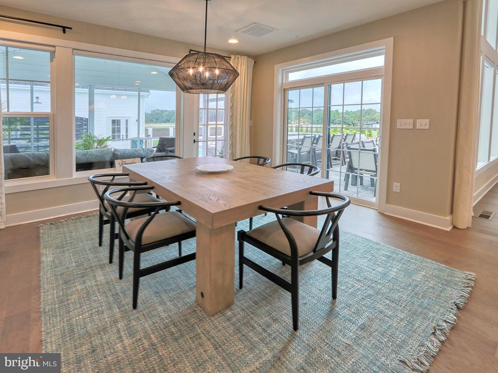 16516 New Road Lewes, DE 19958 - Photo 46 of 109 a view of a dining room and livingroom with furniture wooden floor a chandelier
