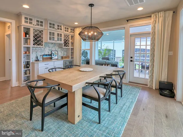 a living room with furniture wooden floor and kitchen view