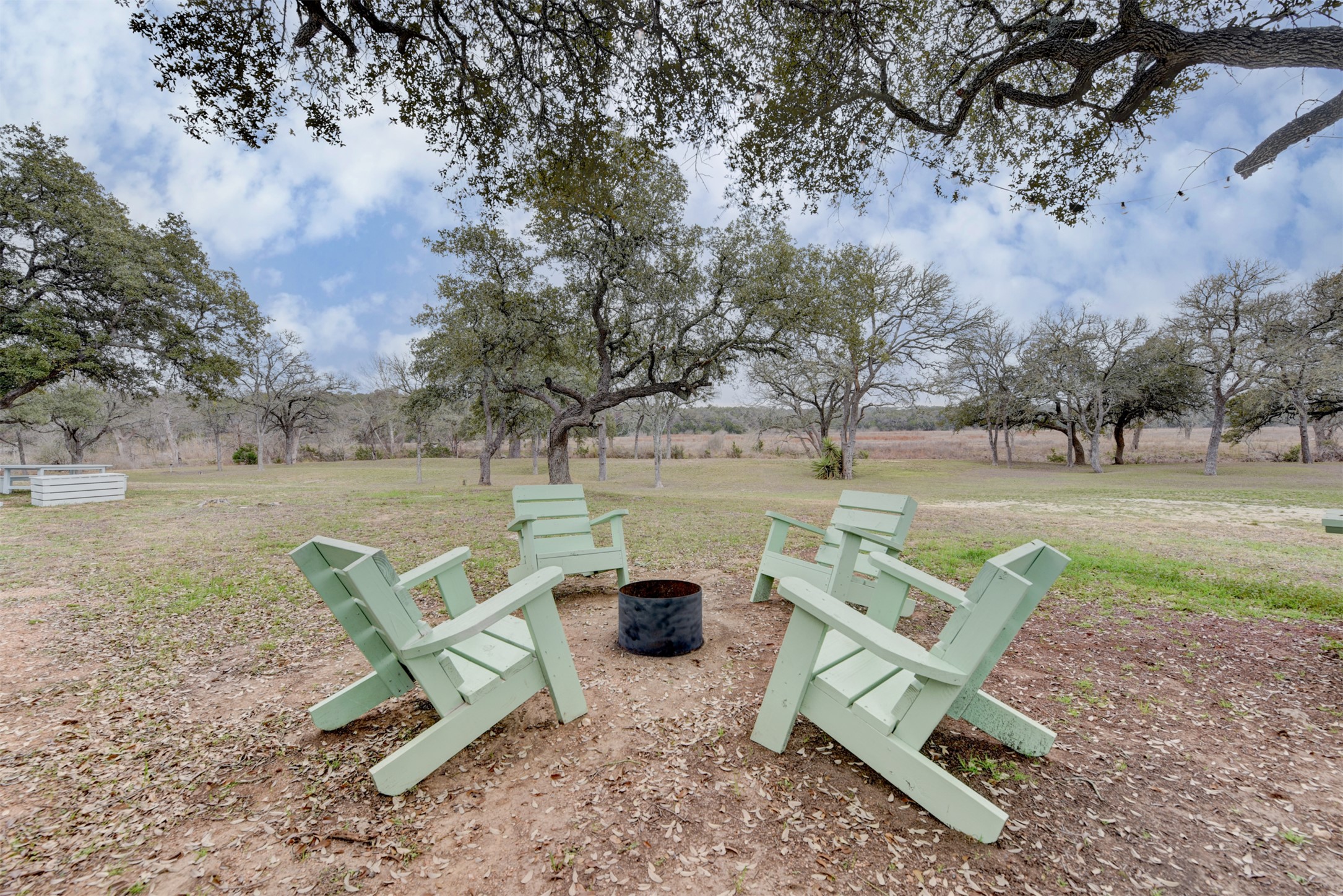 1156 Narrows Road Blanco, TX 78606 - Photo 11 of 40 Expansive outdoor area featuring a fire pit surrounded by four Adirondack chairs