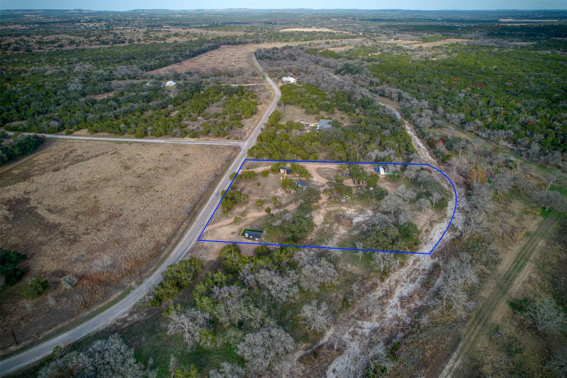 1156 Narrows Road Blanco, TX 78606 - Photo 21 of 40 Expansive rural property featuring a perimeter boundary, multiple structures, established trees, and direct road frontage