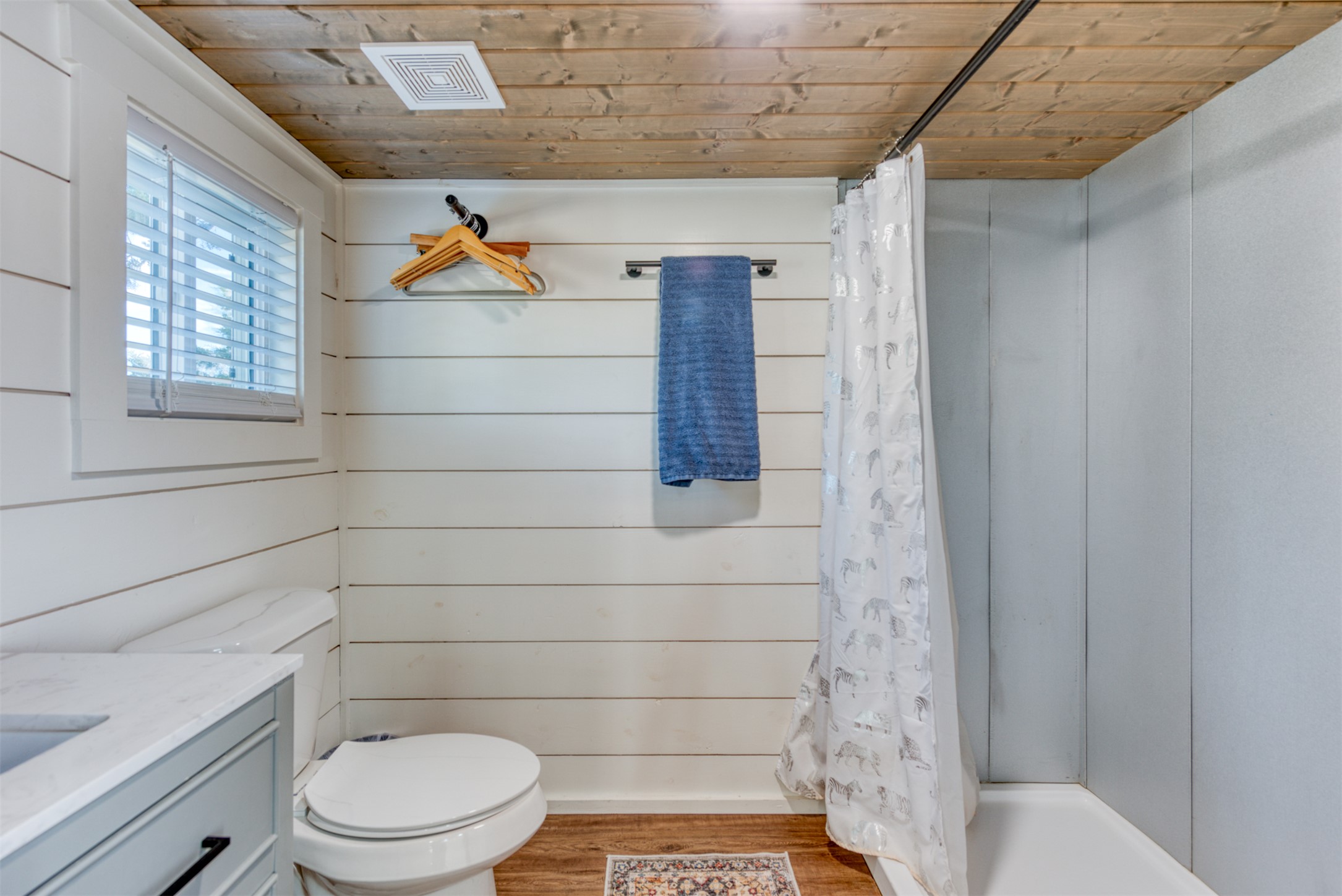 1156 Narrows Road Blanco, TX 78606 - Photo 24 of 40 Bathroom featuring a wood-finish plank ceiling, shiplap wall paneling, and a single-light window with blinds
