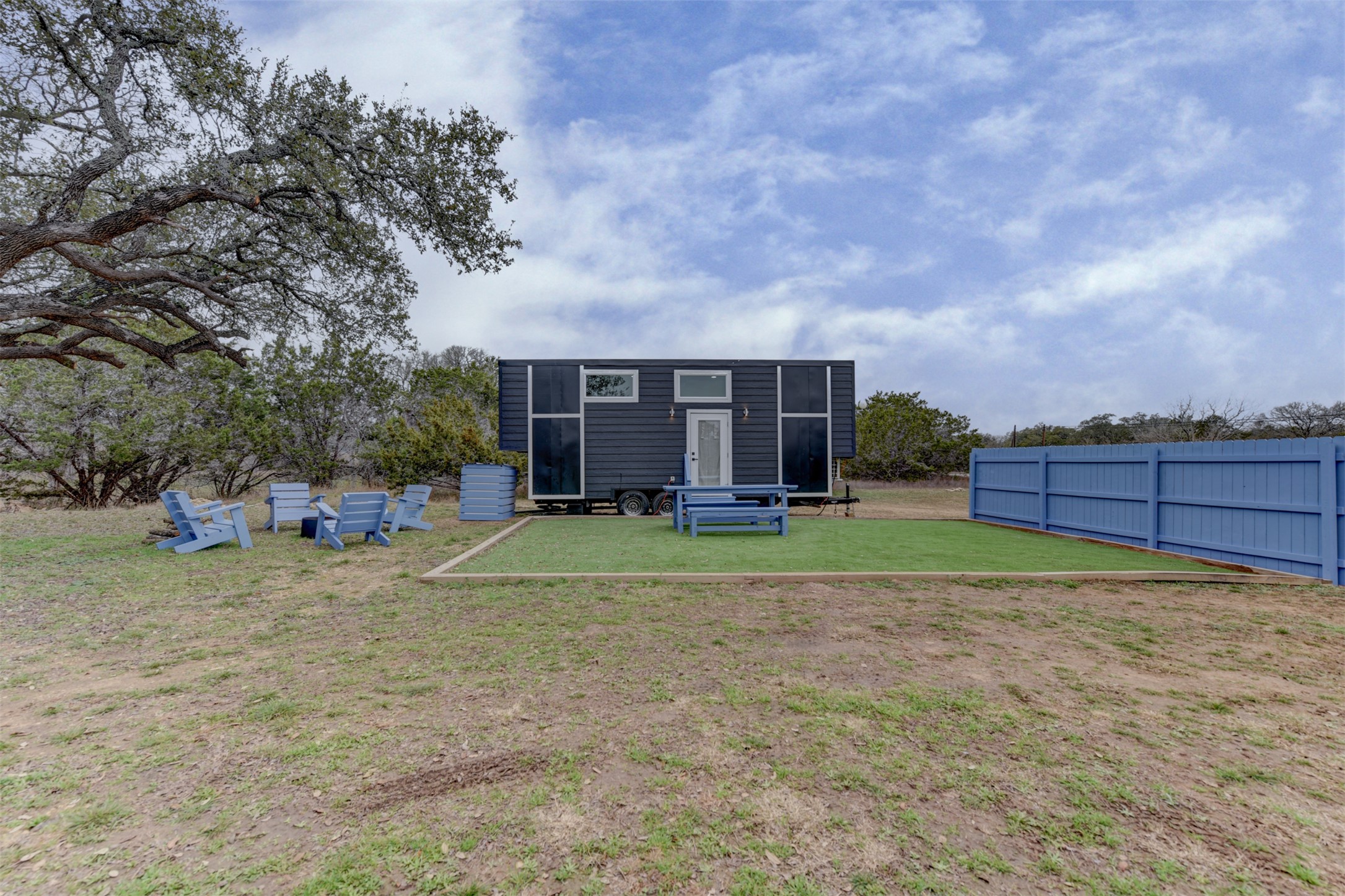 1156 Narrows Road Blanco, TX 78606 - Photo 3 of 40 Modern tiny home featuring a dark exterior, white entry door, and large window panels