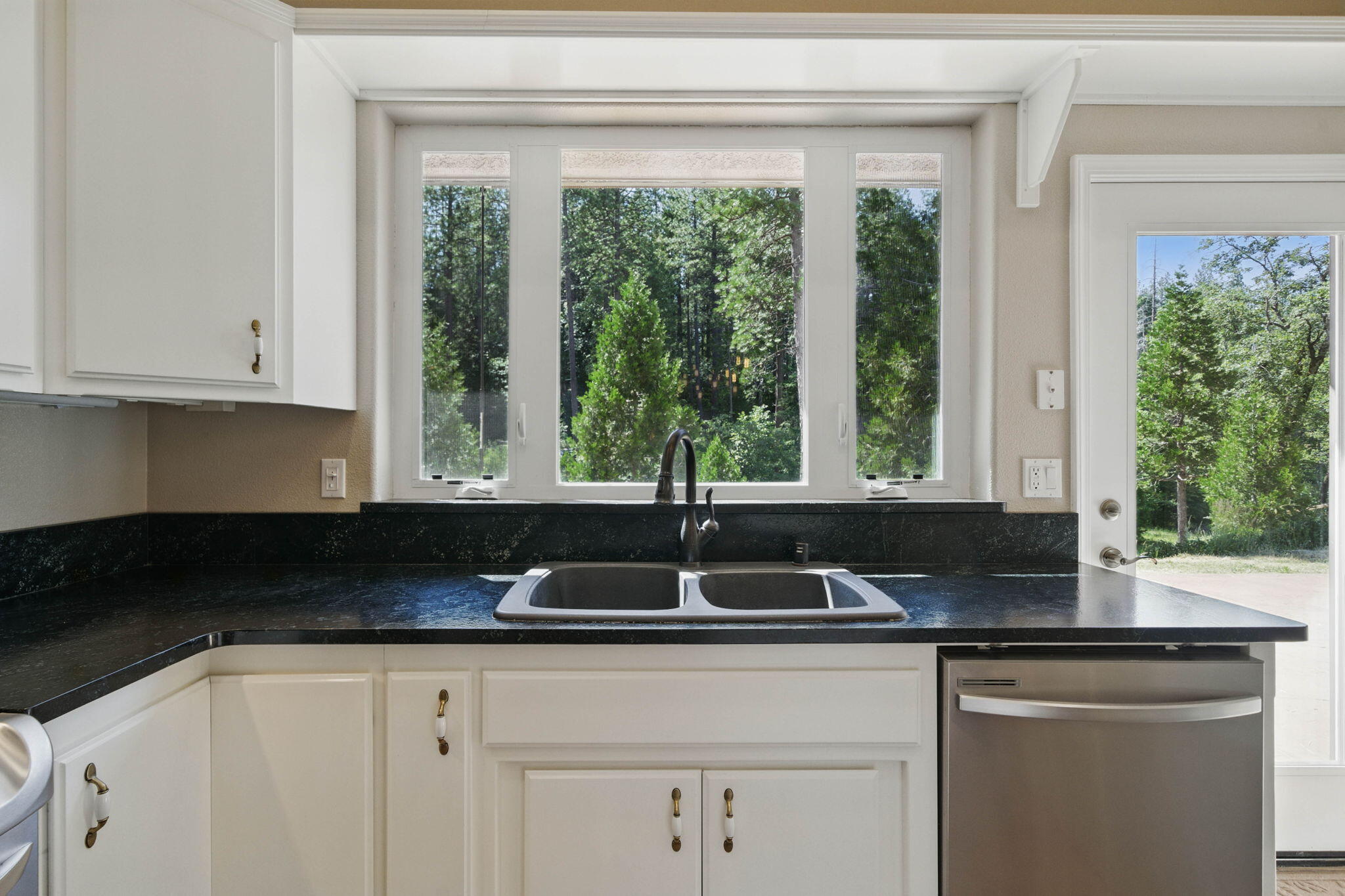 15399 Star Flower Road Oak Run, CA 96069 - Photo 12 of 44 a kitchen with granite countertop a sink and white cabinets