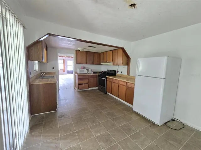 a kitchen with stainless steel appliances granite countertop a refrigerator a sink a stove a microwave and island